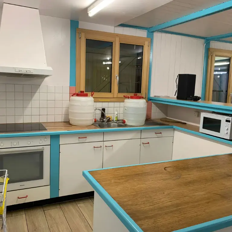 Cuisine équipée du chalet scout Tichodrome à Le Locle avec plaques de cuisson , four et évier